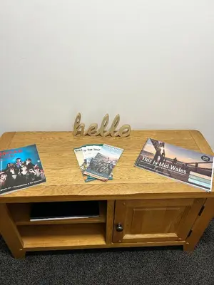 a wooden coffee table with books and magazines on it at Cadwgan House in Rhayader