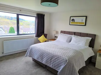 a bedroom with a bed and a large window at Camden Lodge B&B and Cottage Brecon in Brecon