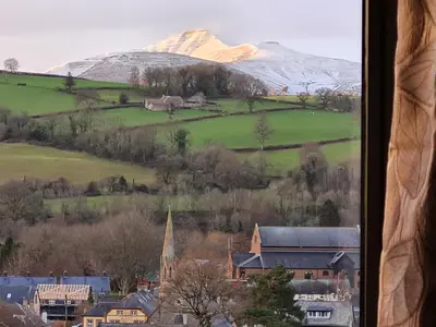 a view of a snow covered mountain from a window at Camden Lodge B&B and Cottage Brecon in Brecon