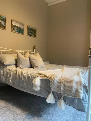 a bedroom with a bed with white sheets and pillows at Lan Y Môr 4 Aberystwyth in Aberystwyth