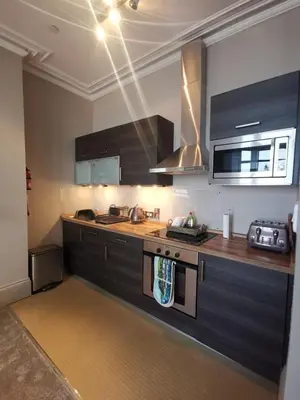 a kitchen with a sink and a stove top oven at Lan Y Môr 4 Aberystwyth in Aberystwyth
