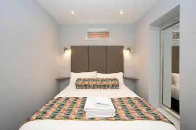 a small bedroom with a bed with towels on it at Townhouse No.1 in Aberystwyth