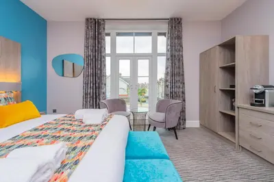 a bedroom with a bed and a desk and a window at Townhouse No.1 in Aberystwyth