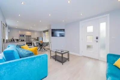 a living room with a blue couch and a table at Townhouse No.1 in Aberystwyth