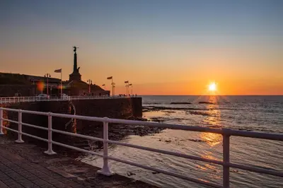 a sunset over the ocean with the statue of liberty at 1 Bed in Aberystwyth oc-bow286 in Aberystwyth