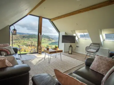a living room with a large window with a view at Tyn Llwyn Barn in Corwen