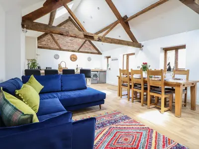 a living room with a blue couch and a table at The Clockhouse in Llandyssil