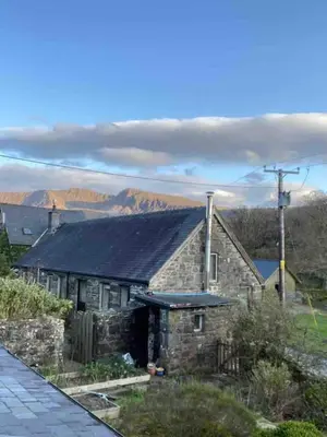 an old stone house with mountains in the background at Panoramic Mountain Retreat - Waen Fechan - 4x4 access only in Dolgellau