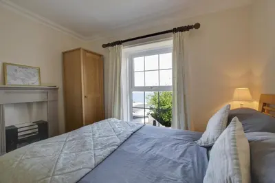 a bedroom with a bed with a fireplace and a window at 4 Bed in New Quay oc-bow272 in New Quay