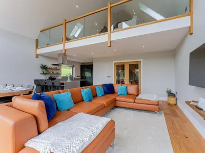 a living room with an orange couch with blue pillows at Coed Y Pentre in Carno
