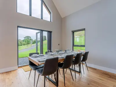 a large dining room with a table and chairs at Coed Y Pentre in Carno