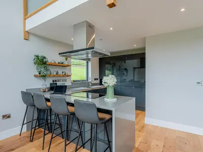 a kitchen with a island with bar stools at Coed Y Pentre in Carno