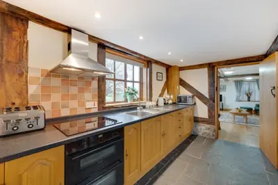 a large kitchen with a sink and a stove at 2 Bed in Y Drenewydd oc-waa401 in Llanllugan
