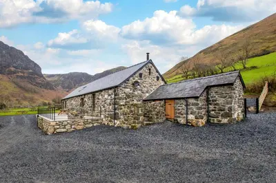 an old stone church with mountains in the background at 4 Bed in Dinas Mawddwy oc-bow305 in Aber Cowarch