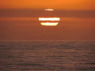 a sunset over the ocean with the sun in the sky at Leahurst Bed and Breakfast in Tywyn
