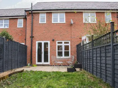 a red brick house with a black fence at Pippin's Place in Shrewsbury