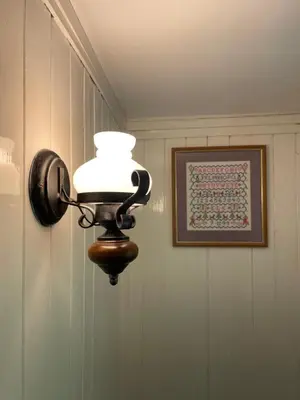 a light fixture on a wall with a picture at 200 year old Gardener's cottage, Mid Wales in Llanidloes