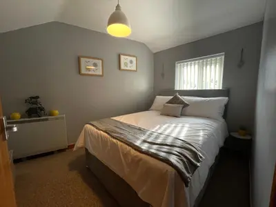 a bedroom with a bed with white sheets at Westend Holiday Let 3 Brecon in Brecon