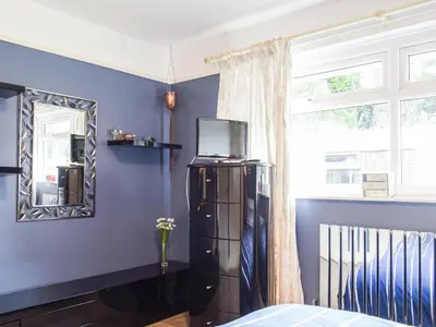 a bedroom with blue walls and a mirror at Rhiw Gam in Abbey-Cwmhir