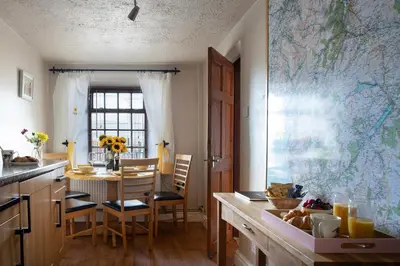 a kitchen with a table and a dining room at Homely cottage with garden and mountain-view in Blaenau-Ffestiniog