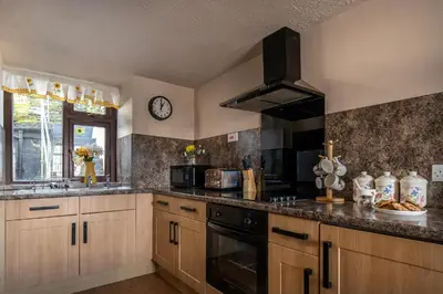 a kitchen with a sink and a stove top oven at Homely cottage with garden and mountain-view in Blaenau-Ffestiniog