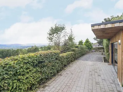 a walkway leading to a house with a wooden structure at Hilltop Lodge in Corwen
