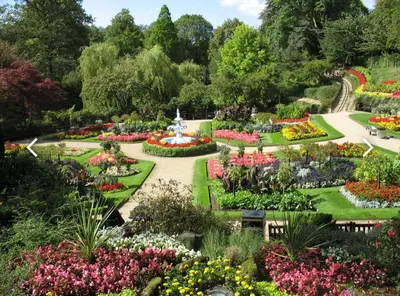 a garden with flowers and a fountain in the middle at NiCheGetaway in Shrewsbury