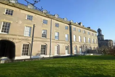 a large building with a grassy field in front of it at NiCheGetaway in Shrewsbury