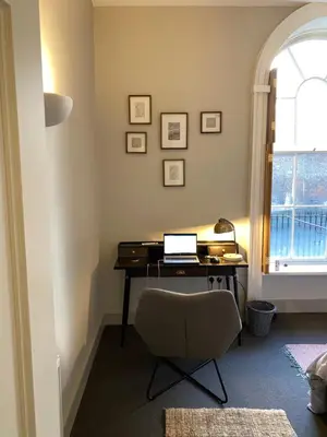 a desk with a laptop on it in a room with a window at NiCheGetaway in Shrewsbury