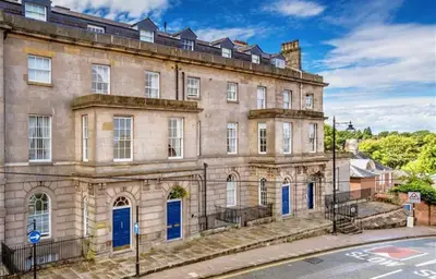 a large stone building with blue doors on a street at NiCheGetaway in Shrewsbury