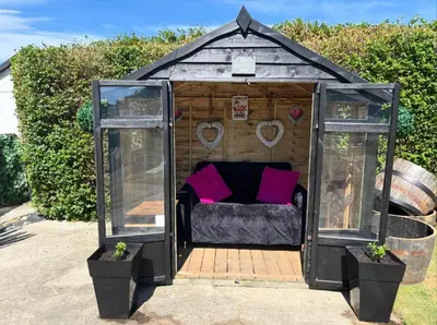 a gazebo with a bed and two windows at The Queens Hotel Harlech in Harlech
