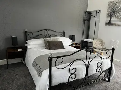 a bedroom with a black and white bed with white pillows at The Queens Hotel Harlech in Harlech