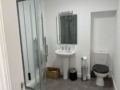 a bathroom with a toilet and a sink and a shower at The Queens Hotel Harlech in Harlech