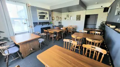 a dining room with wooden tables and chairs at The Queens Hotel Harlech in Harlech