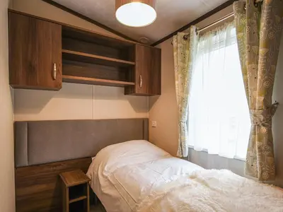 a small bedroom with a bed and a window at Avon Lodge in Hyssington