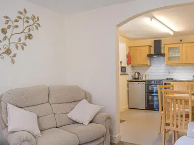 a living room with a couch and a kitchen at Border View in Kington