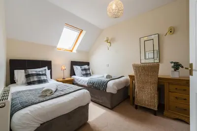 a bedroom with two beds and a mirror at The Granary, Bryncarnedd cottages in Aberystwyth