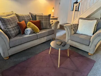a living room with two couches and a table at Abbey Cottage in Llangollen