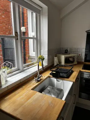 a kitchen with a sink and a microwave on a counter at Cartref - Fully equipped and stunning town flat in Shrewsbury
