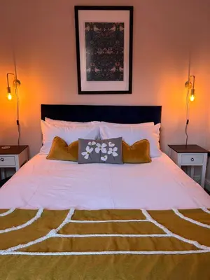 a bedroom with a large white bed with two lamps at Cartref - Fully equipped and stunning town flat in Shrewsbury