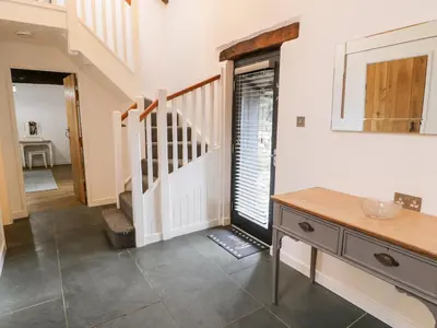 a hallway with a staircase and a table in a house at Beudy Bach in Llanbedr