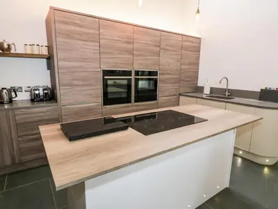 a kitchen with a counter top with a stove at Beudy Bach in Llanbedr