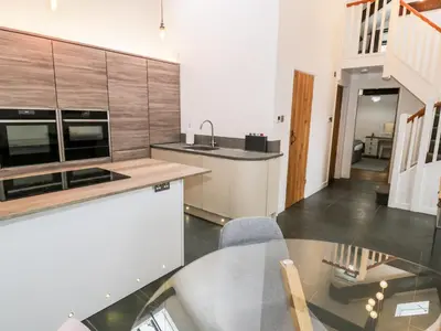 a kitchen with a glass table and a sink at Beudy Bach in Llanbedr