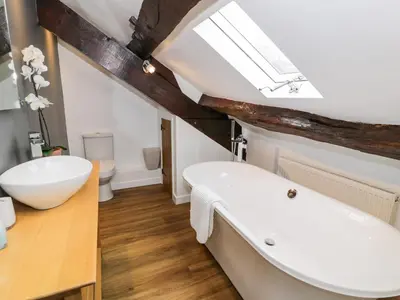 a bathroom with a white tub and a sink at Beudy Bach in Llanbedr