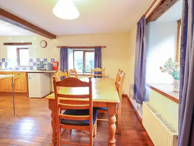 a kitchen and dining room with a table and chairs at Yr Hen Felin in Oswestry