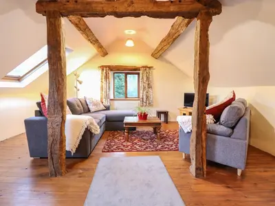 a living room with two couches and a table at Yr Hen Felin in Oswestry