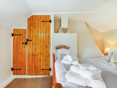 a bedroom with a bed with white towels on it at Elsie's Cottage in Pontesbury