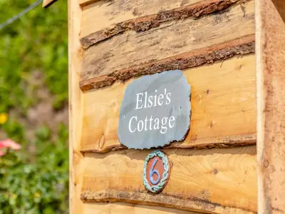 a sign on the side of a wooden building at Elsie's Cottage in Pontesbury