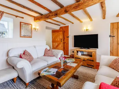 a living room with a couch and a tv at Elsie's Cottage in Pontesbury