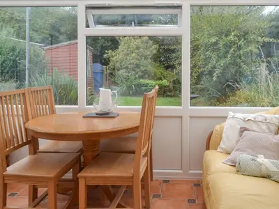 a dining room with a table and chairs and a window at The Snug in Aberaeron